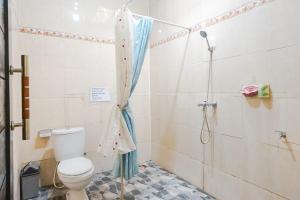 a bathroom with a toilet and a shower at Green View Ubud Hostel Bali in Ubud