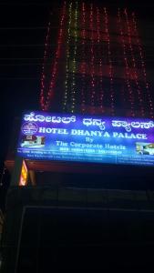 een bord aan de zijkant van een gebouw met verlichting bij Hotel Dhanya Palace By Corporate Hotelz in Bangalore