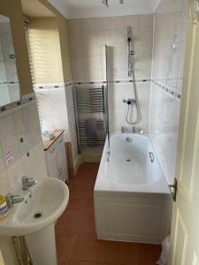 a bathroom with a tub and a sink and a shower at Tal Y Don Hotel in Barmouth