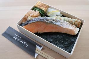 a plate of sushi with a piece of meat and chopsticks at Agora Tokyo Ginza in Tokyo