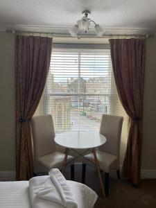 a bedroom with a table and two chairs and a window at Tal Y Don Hotel in Barmouth