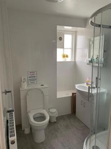 a white bathroom with a toilet and a sink at Tal Y Don Hotel in Barmouth