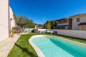 a swimming pool in a yard next to a house at ByNos Pool - Primo Piano in Santa Maria Navarrese