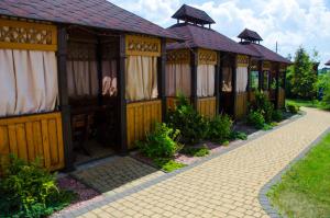 a row of wooden buildings with curtains on a sidewalk at Europe in Solonka