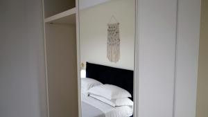 a mirror in a bedroom with white sheets and pillows at Corte Cesarina in Porto Cesareo +223 photos