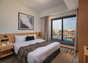pokój hotelowy z łóżkiem i dużym oknem w obiekcie Creek Hotel and Residences El Gouna w mieście Hurghada