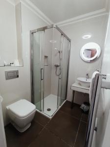 a bathroom with a shower and a toilet and a sink at Anchor Hotel and Seabed Restaurant in Tarbert