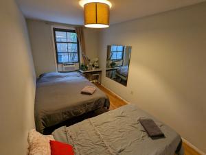 a small bedroom with two beds and a mirror at Private room in 4 bedroom Ground Apartment near Subway in Brooklyn