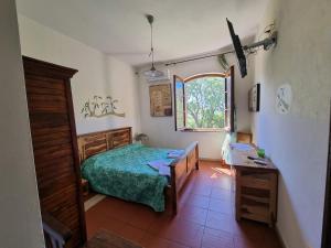 a bedroom with a bed and a table and a window at Agriturismo Le Rondini Di San Bartolo in San Vincenzo +97 photos