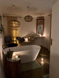 a bath tub in a bathroom with candles and lights at Tjimaka Farm in Hazyview