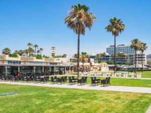 a restaurant with tables and chairs and palm trees at Cubo's Apartamento Perla del Sol 3I in Torremolinos