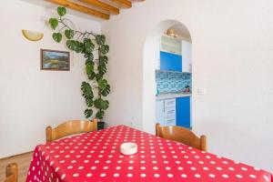 una mesa de comedor con un paño rojo de lunares en Sunset house with seaview en Hvar