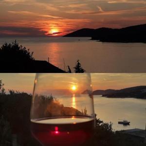 una copa de vino con la puesta de sol en el fondo en Sunset house with seaview, en Hvar