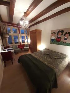 um quarto com uma cama, uma secretária e janelas em Cathédrale em Estrasburgo