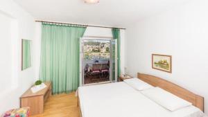 1 dormitorio con 1 cama y ventana con mesa en Sunset house with seaview en Hvar