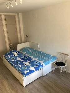 a bedroom with a bed with a blue comforter at Modern city studio with own patio in Helsinki
