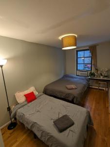 a bedroom with two beds and a lamp at Private room in 4 bedroom Ground Apartment near Subway in Brooklyn