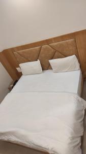 a large white bed with two pillows on it at HOTEL GANGARANI in Haridwār