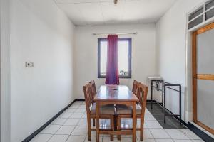 a dining room with a wooden table and chairs at Abang Hotel Ciwidey in Bandung