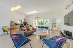a living room with a couch and chairs and a table at Domaine Villas Mandarine Private Pools & Spa in Calvi