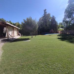 un gran patio de césped con un edificio y árboles en El Coiron en Colonia Las Rosas