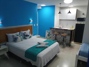 um quarto azul com uma cama e uma cozinha em SUITES VISTA MAR AZUL em Saquarema