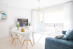 a living room with a white table and a blue couch at Cubo's Apartamento Perla del Sol 3I in Torremolinos