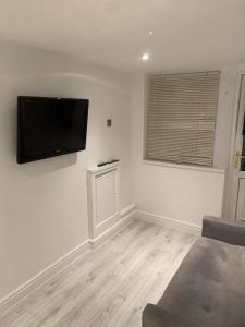 a living room with a flat screen tv on the wall at Studio garage conversion in Matson