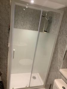 a shower with a glass door in a bathroom at Studio garage conversion in Matson