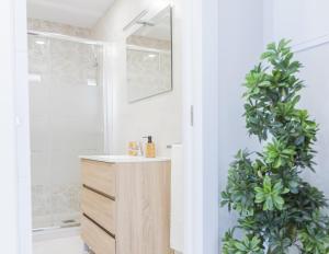 a bathroom with a sink and a shower with a plant at Cubo's Apartamento Perla del Sol 3I in Torremolinos +40 photos