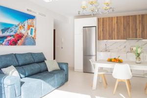 a living room with a blue couch and a kitchen at Cubo's Apartamento Perla del Sol 3I in Torremolinos