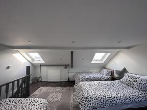 a room with two beds and skylights at Adanhouse-stockland spacious 5 bedroom house sleeps 12 private garden in Cardiff