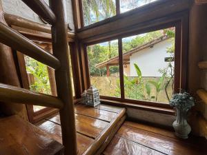 Habitación con ventana grande y suelo de madera. en Casa com Piscina, Barra do Una., en São Sebastião