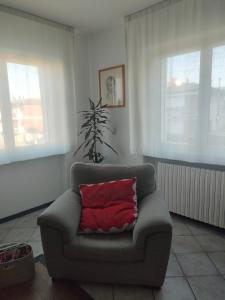 a couch with a red pillow in a living room at Ca Bilofer Airport Apartment in Seriate