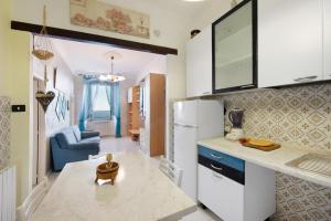 una cucina con frigorifero bianco e un soggiorno di La Finestra sul Mare a Genova