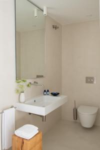 Baño blanco con lavabo y aseo en The Onsider - Luxury Apartment with 3 bedrooms and 2 private patios, en Barcelona