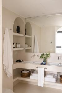 Baño blanco con lavabo y espejo en The Onsider - Luxury Apartment with 3 bedrooms and 2 private patios, en Barcelona