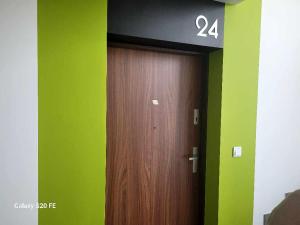 una puerta de madera en una habitación con paredes verdes en Apartament Mistral en Cracovia