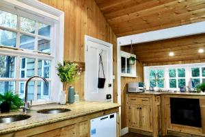 a kitchen with wooden walls and wooden counters at 3 Bed Cabin in the Woods in Barham