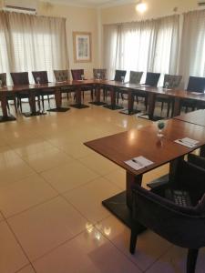 マウンにあるOkavango Roadside Guesthouseの長いテーブルと椅子が備わる広い客室です。