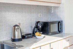 a kitchen counter with a microwave and a sink at Positive vibes: Athens studio in Athens