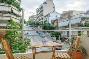a table and two chairs on a balcony with a street at Positive vibes: Athens studio in Athens