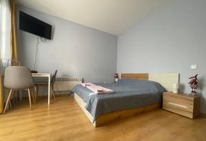 a bedroom with a bed and a desk and a television at Ваканционно жилище-Боровец in Borovets