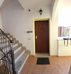 pasillo con escaleras y puerta de madera en Casa di Lu, en SantʼAntìoco