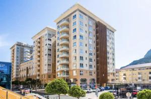 un gran edificio de apartamentos en un aparcamiento en West One Studio Apartments, en Gibraltar