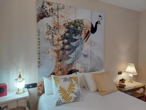 a bedroom with a large peacock painting on the wall at Un mar de pinares 