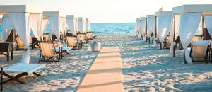 een rij stoelen en parasols op een strand bij Versilia Tonfano villetta in Marina di Pietrasanta