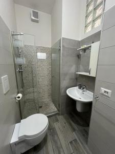 a bathroom with a shower and a toilet and a sink at La casa di pinocchio in Bacoli
