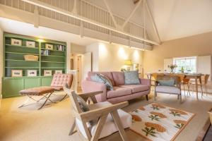 uma sala de estar com um sofá rosa e uma mesa em Water Mill House em Burnham Market