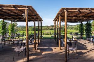 a patio with tables and chairs under a pavilion at Locanda dell'Aioncino in Bibbona
